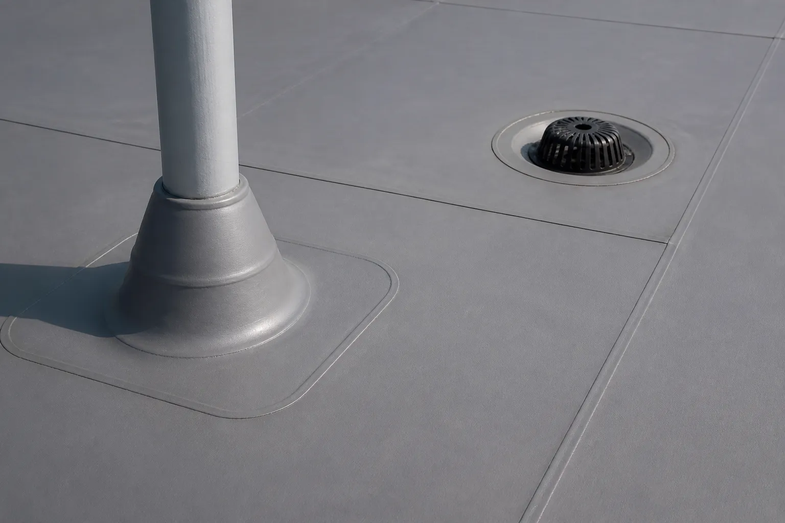 Commercial roof membrane seam, pipe penetration flashing, and nearby roof drain