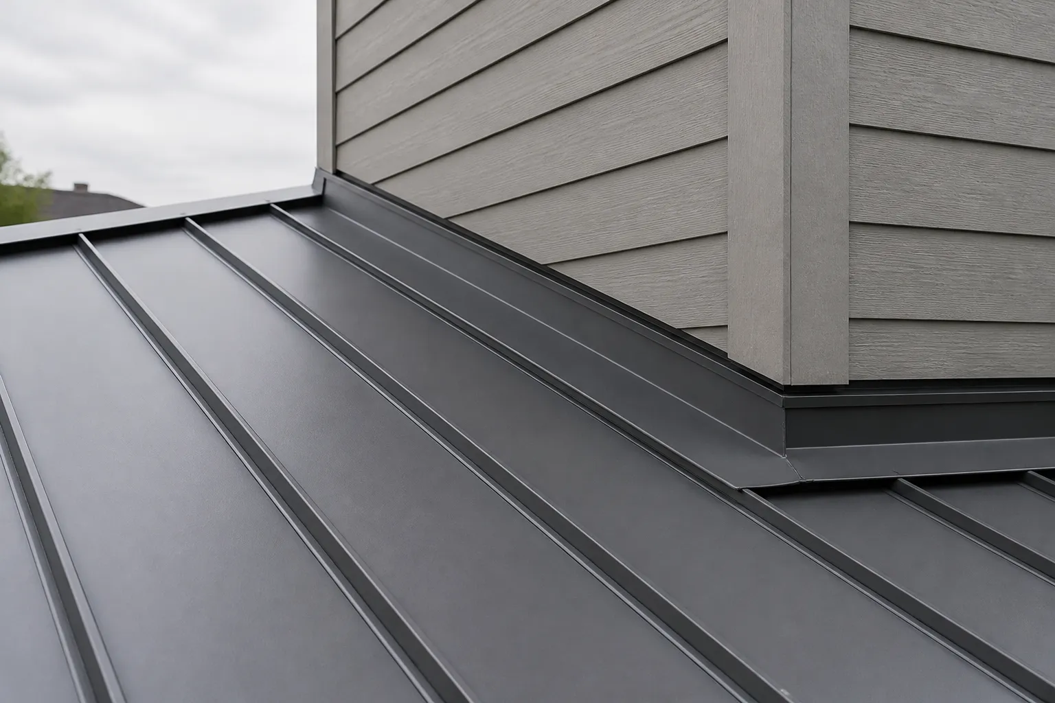 Standing-seam metal roof panels with raised seams and roof-to-wall flashing.