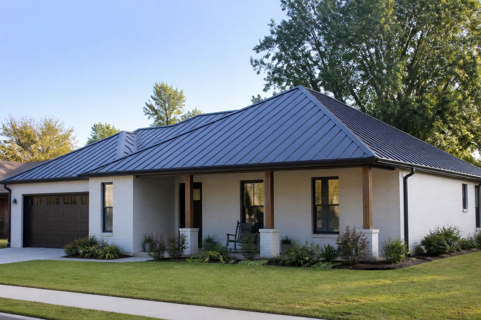 Dark standing-seam metal roof on a brick home in De Queen, Arkansas, with a covered porch and trees nearby.