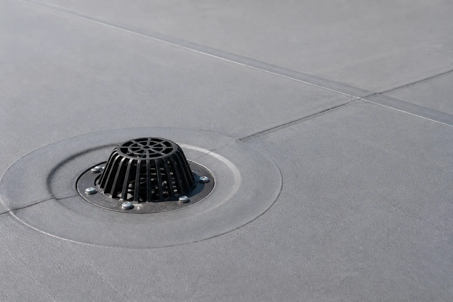 Commercial membrane roof drain with the membrane properly dressed into the drain assembly and seams nearby