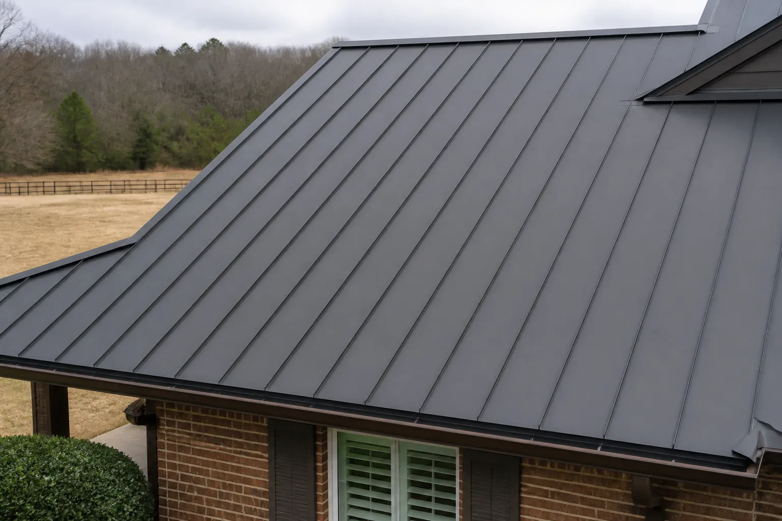 Close view of standing-seam metal roof panels and flashing at a roof transition