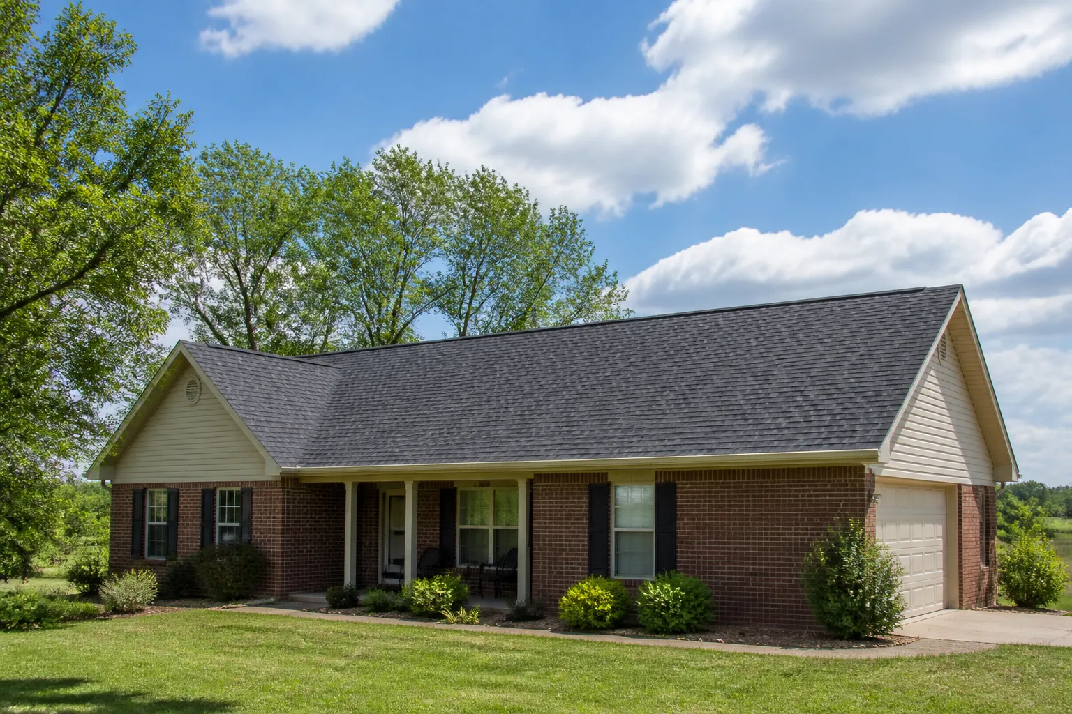 A single-story Arkansas home with a clean shingle roof under open sky in Osceola