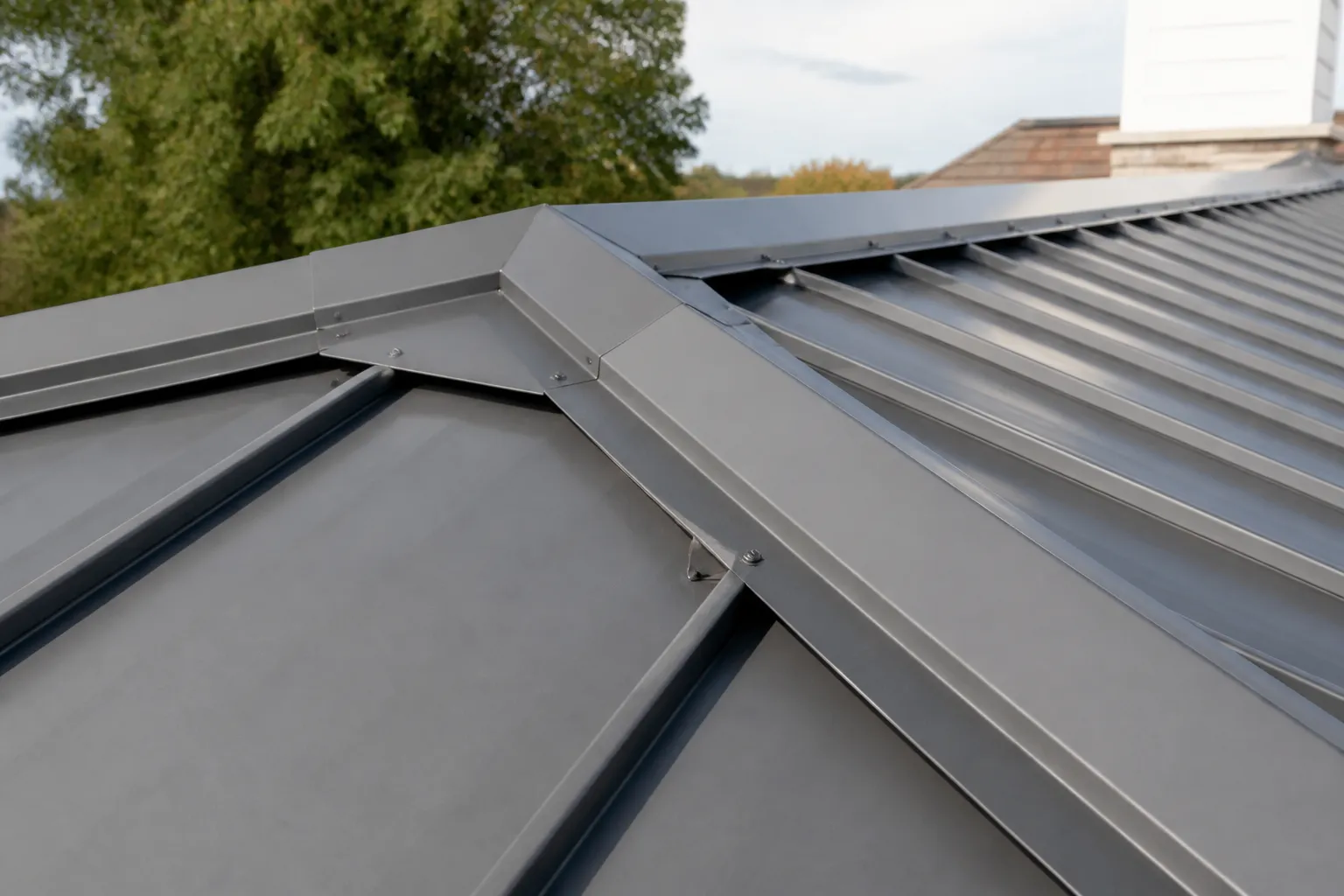 Standing-seam metal roof panels meeting a formed flashing transition