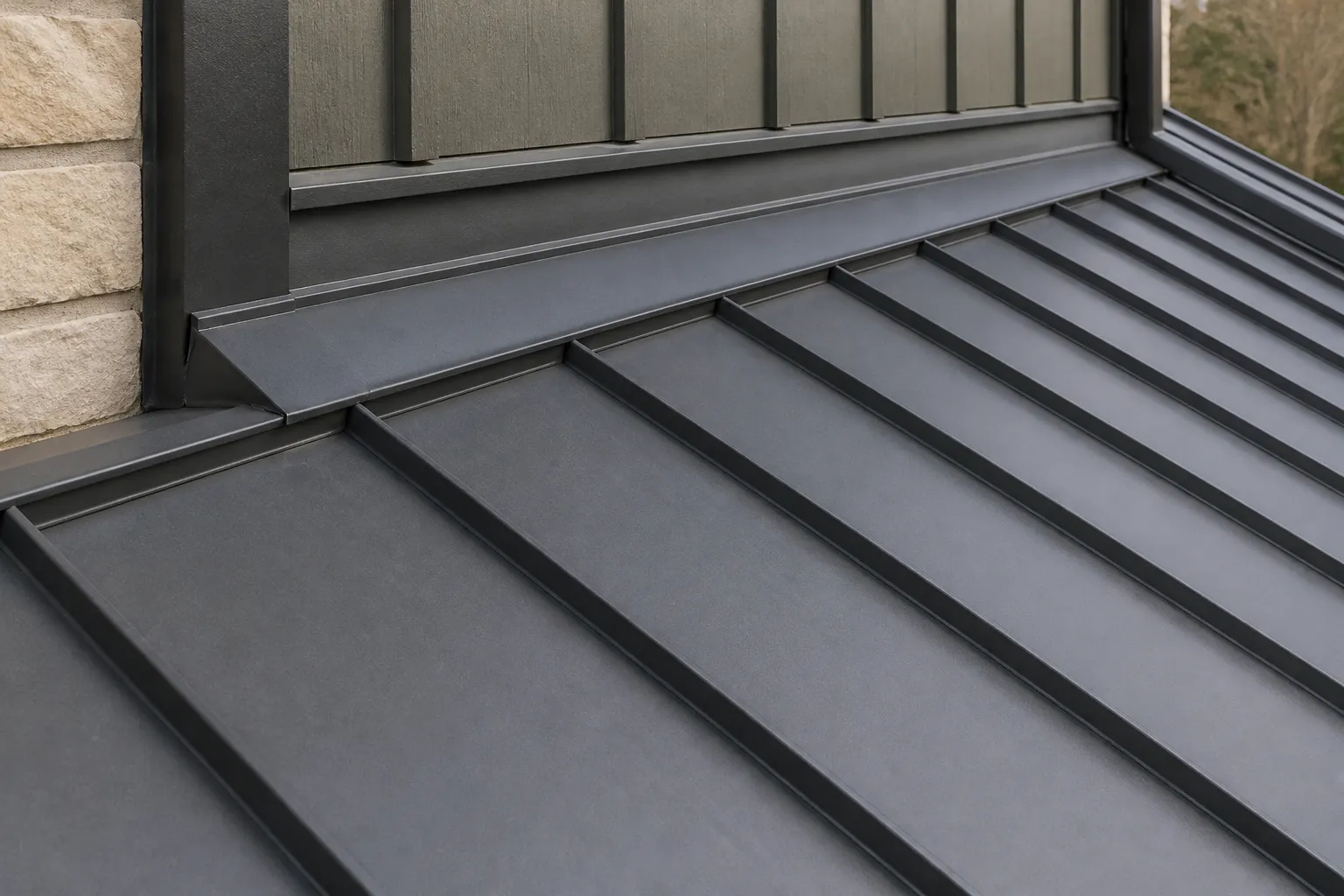 Standing-seam metal roof panels meeting flashing at a roof-to-wall transition